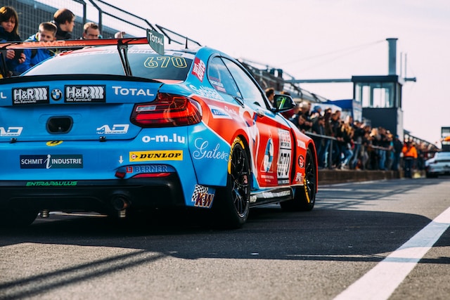 Blue racing car in front of spectators